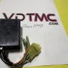 Black automotive relay with multi-colored wires and a yellow connector on a white surface.