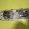 Metal hardware parts inside a clear plastic blister on a white backing card, with 'Made in Japan' text visible on the card.