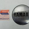 Yamaha genuine parts label beside a round chrome Yamaha emblem cap.