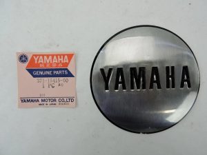 Yamaha genuine parts label beside a round chrome Yamaha emblem cap.