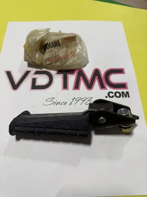 Small Yamaha motor part wrapped in plastic resting on a white sheet with pink/black 'VDMC' text visible underneath