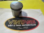 Piston resting on a Vintage Dirt & Trail Motorcycles logo mat with Since 1993 text.