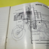 s-l140-3 Open notebook page featuring a detailed technical diagram of a machine's internal components, with various labeled parts and overlapping circular shapes.