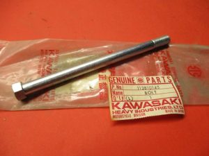 s-l500 Long silver hex bolt with threaded end, resting on a Kawasaki Genuine Parts bag (motorcycle part).