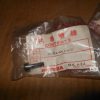 Honda parts bag labeled 'Contents' with a small black pin on a wooden surface