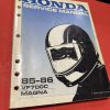 IMG_2153 Honda service manual cover with blue gradient and motorcycle helmet illustration, 85-86 VF700C Magna edition visible on white spine set on red surface