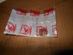 Crumpled white plastic bag with red Honda logos spread on a wooden surface on a table