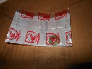 Crumpled white plastic bag with red Honda logos spread on a wooden surface on a table