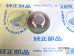 Close-up of a hex bolt head resting on a Honda Genuine Parts box with blue logos and Japanese text