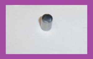 Gray cylindrical pipe stub protruding from a white wall.