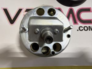 Close-up of a silver metal valve housing with several round ports and bolts.