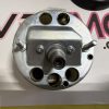 Close-up of a silver metal valve housing with several round ports and bolts.