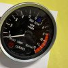 Close-up of a motorcycle tachometer displaying RPM x1000, with numbers 0–12, a blue indicator, redline area, and Yamaha/Nippon Seiki branding visible.