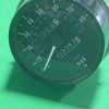 Close-up of a car analog speedometer showing 0–130 mph with a rectangular odometer display against a green background.