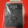 Compact black box labeled 'Chess Manual' with a grid/checker design, shrink-wrapped and placed on a bright red surface.