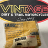s-l140 Vintage Dirt & Trail Motorcycles sign with an oval logo, accompanied by two yellow Yamaha oil bags on a counter
