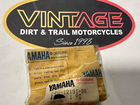 Vintage Dirt & Trail Motorcycles sign with an oval logo, accompanied by two yellow Yamaha oil bags on a counter