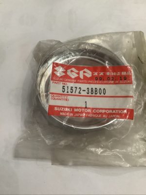Suzuki genuine part label on a metal circular component in a plastic bag; part no. 51572-38B00, quantity 1, made in Japan.