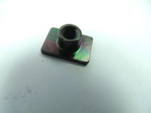 Small metal threaded insert on a square rainbow-colored base plate against a white background.
