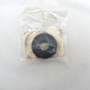 Small plastic bag containing a black circular gasket with a central hole on a beige backing surface