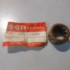 Small cylindrical bearing sleeve (inner race) next to a red Suzuki spare parts tag showing part number 09263-19009.