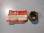 Small cylindrical bearing sleeve (inner race) next to a red Suzuki spare parts tag showing part number 09263-19009.