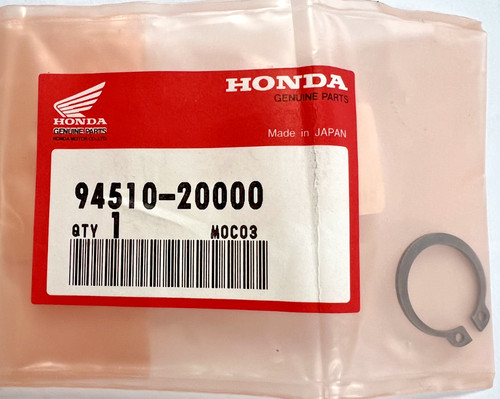 Honda genuine parts bag with red label reading 94510-20000, quantity 1,Made in Japan, plus a small circular metal retaining ring beside the bag.