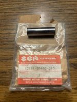 Cylindrical metal pin resting on a plastic-bag Suzuki Genuine Parts label showing part number 12151-35400-000.