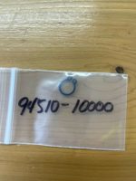 Small resealable plastic bag on a wooden table with the handwritten number 94510-10000 and a blue ring drawing on it.