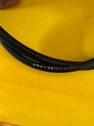 Curved black cable resting on a bright yellow surface, close-up view