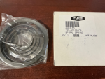 s-l500 Coiled metal bearing sealed in plastic next to a white box with a barcode on a wooden surface.